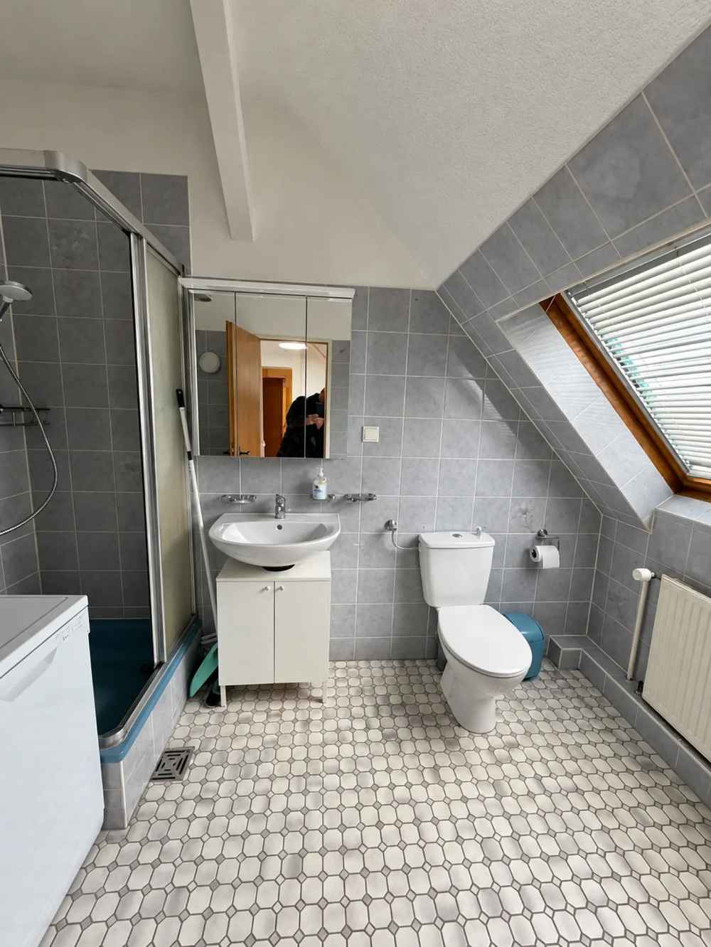 Eigenes Badezimmer mit grauen Fliesen, Dusche, Waschbecken und Dachfenster
