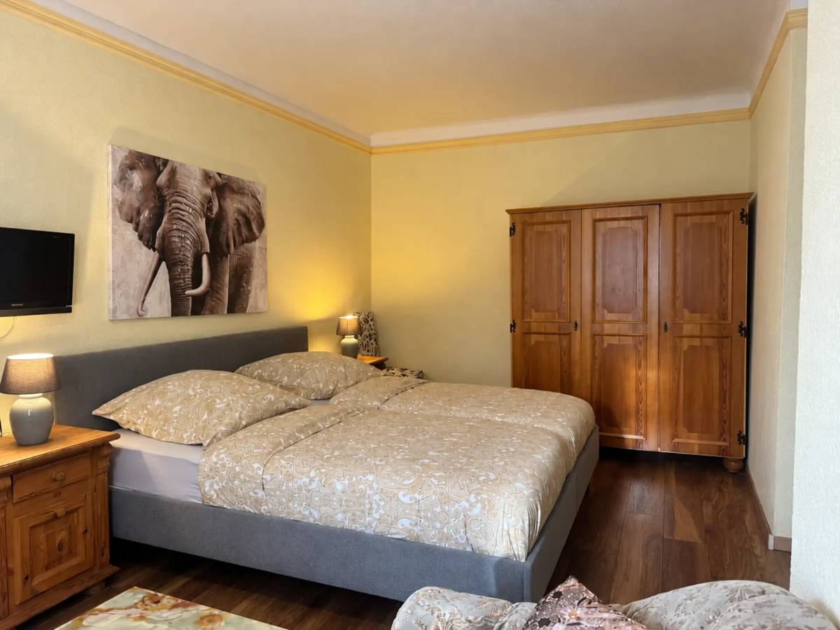 Gästezimmer mit Doppelbett, Elefantenbild und Holzschrank